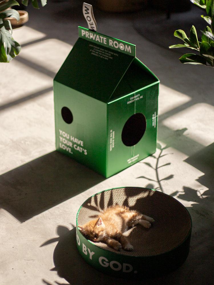 milk-carton-shaped cardboard cat house featuring a circular entrance